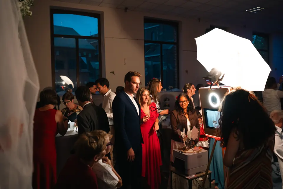 Un couple pose devant la borne photobooth pendant la soirée.